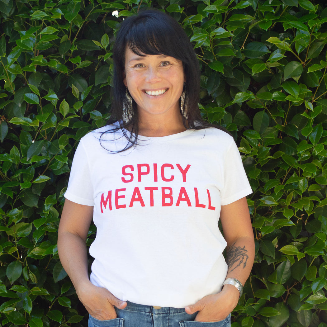 Smiling and happy woman wears a t-shirt emblazoned with the phrase Spicy Meatball